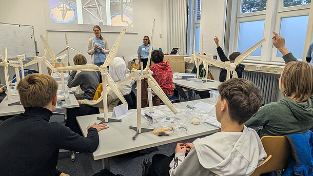 Eine Schülergruppe baut in einem Workshop Modelle von Windenergieanlagen zusammen.